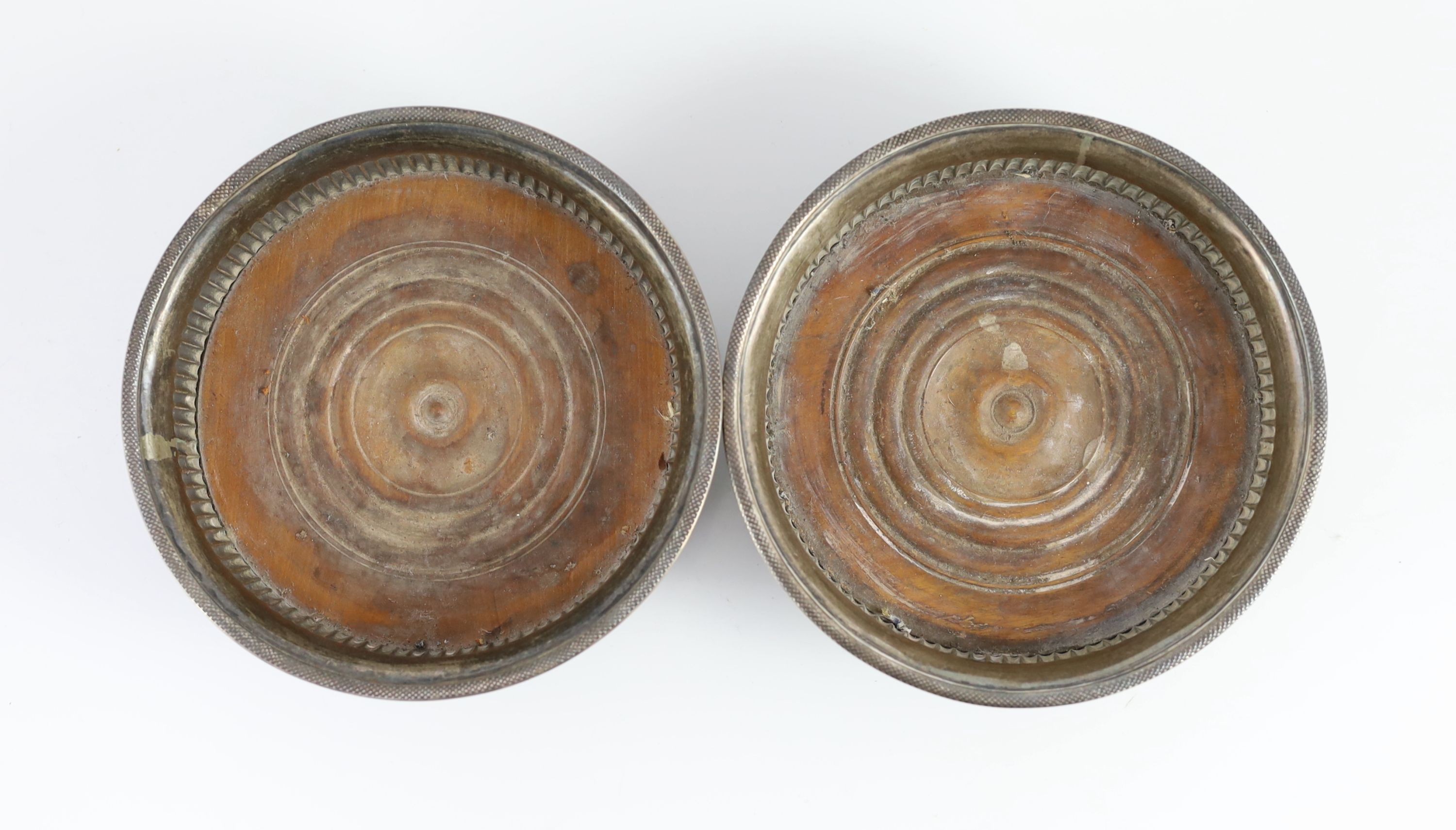 A matched pair of George III silver mounted wine coasters, one by John Love & Co, Sheffield circa 1790, the other by John Roberts & Co, Sheffield, 1807